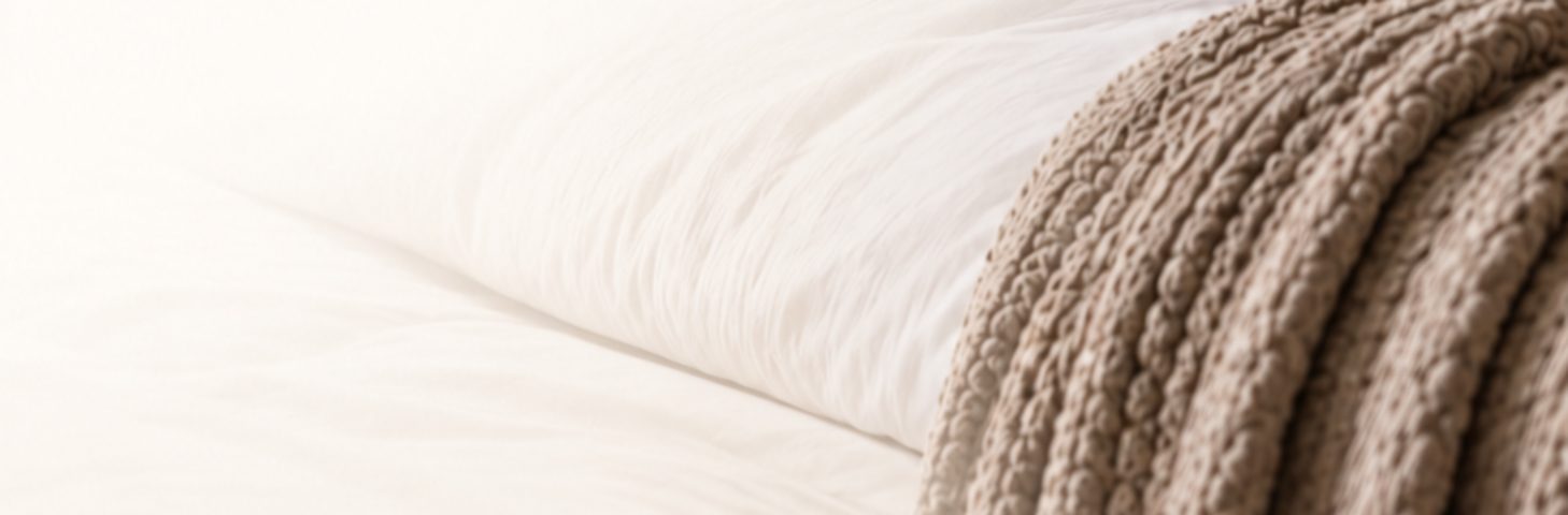 White bedding with a soft knit throw